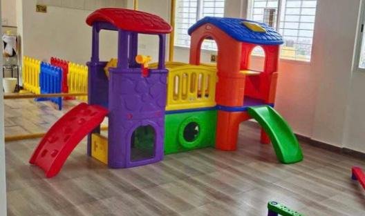 Indoor play structure with climbing platforms, bridge and slides